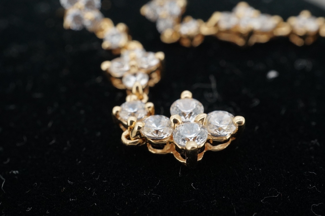 A modern yellow metal (stamped 585) and cubic zirconia set line bracelet, 18cm and a pair of similar drop earrings, together with a similar 9k and cubic zirconia set cluster ring, size N.